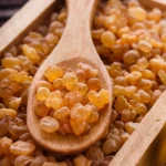 Suszona oleożywica olibanum (kadzidłowiec) w drewnianej łyżce, używana do produkcji eterycznego olejku olibanowego (kadzidłowego)