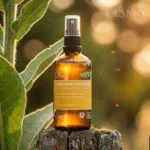 Butelka Dziewannowy Ziołoocet stojąca na drewnianym słupku w świetle zachodzącego słońca.