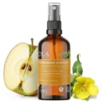 Butelka Dziewannowy Ziołoocet w otoczeniu przekrojonego jabłka i świeżego kwiatu dziewanny.