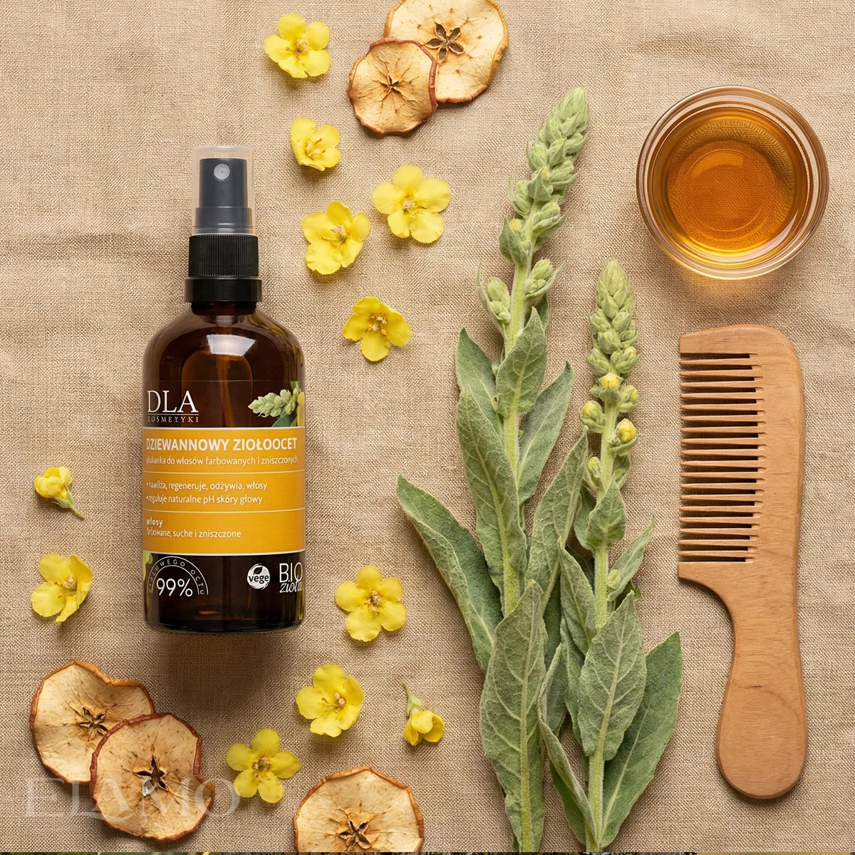 Widok z góry na Dziewannowy Ziołoocet, drewniany grzebień, suszone jabłka i miseczkę z octem na lnianym tle.