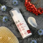 Bogata konsystencja kremu na noc, plaster miodu, owoce jarzębiny i niebieskie kwiaty czarnuszki na kamiennym tle