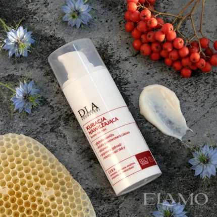 Bogata konsystencja kremu na noc, plaster miodu, owoce jarzębiny i niebieskie kwiaty czarnuszki na kamiennym tle