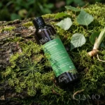 Naturalny szampon Koperkowa Włosomyjka stojący na omszałym pniu w lesie