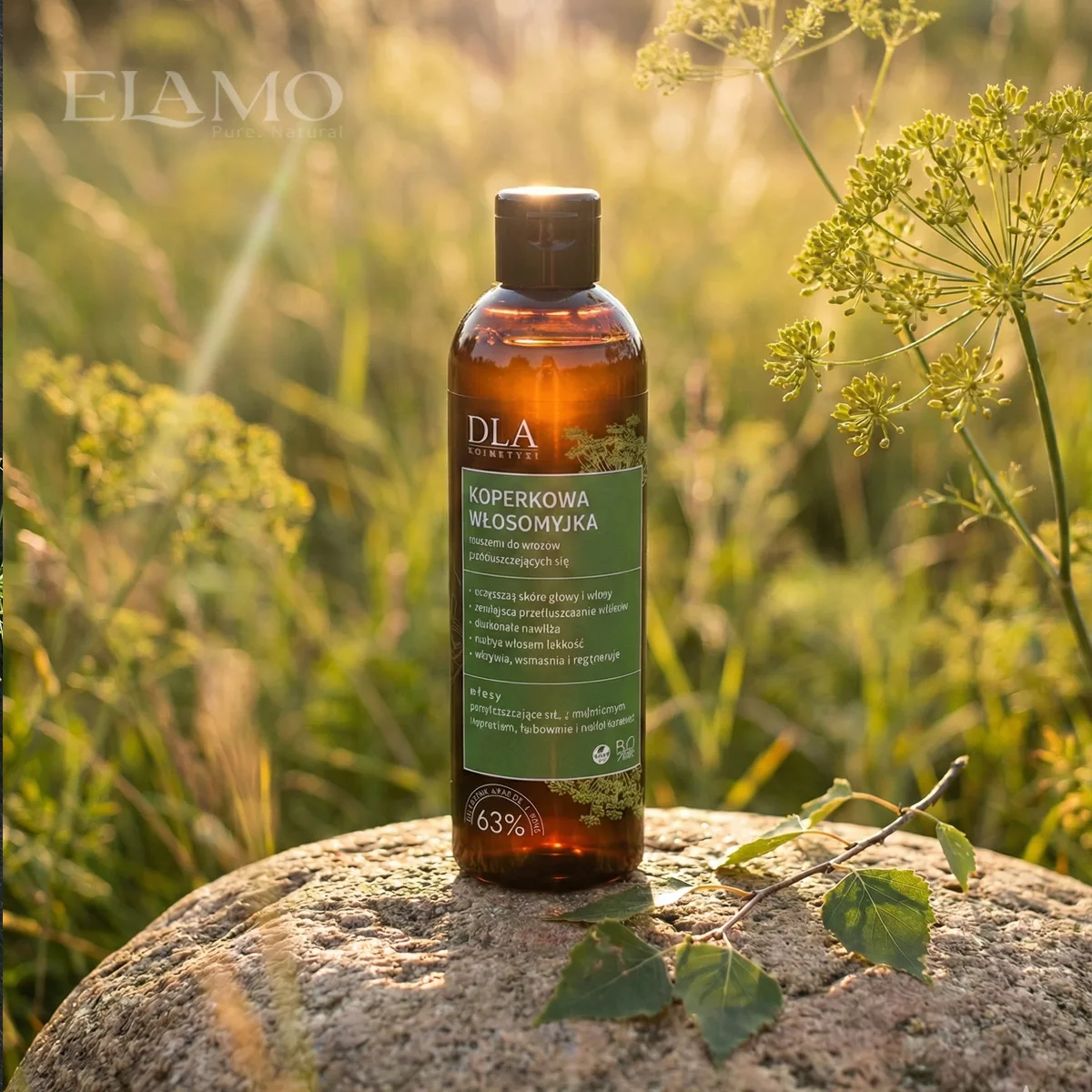 Szampon Koperkowa Włosomyjka w słońcu na łące bursztynowa butelka