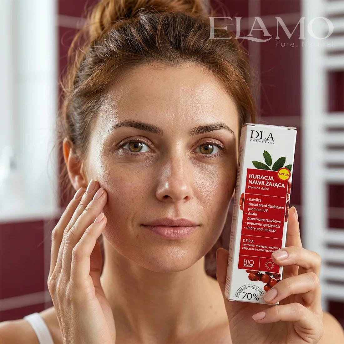 Kobieta o naturalnej, promiennej cerze trzymająca opakowanie kremu Kuracja Nawilżająca na dzień z filtrem SPF 15