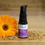 Buteleczka serum DLA na drewnianym tle w otoczeniu nasion kozieradki