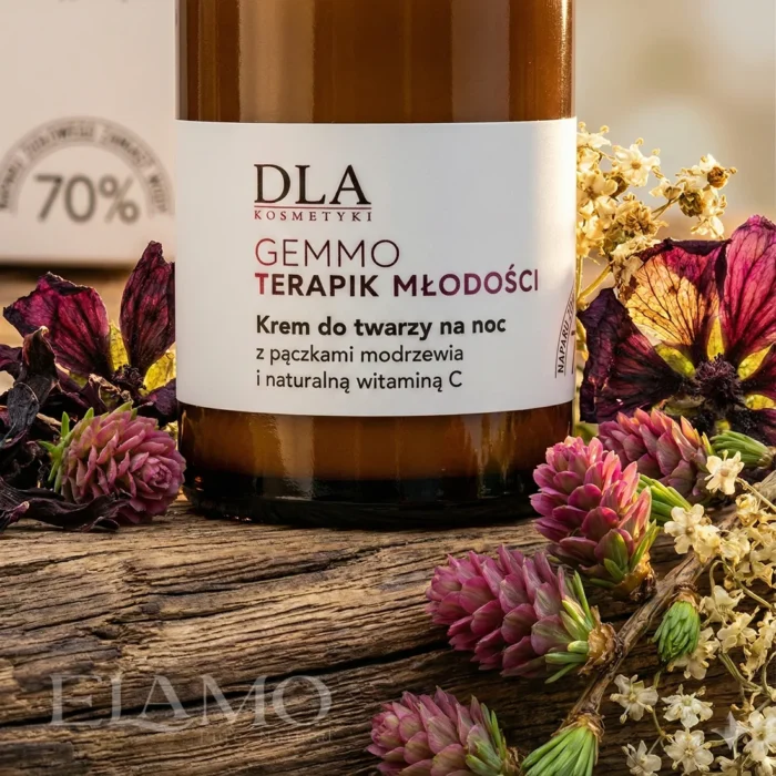 Szklana butelka kremu Gemmoterapik na tle naturalnego drewna, pąków modrzewia i suszonych kwiatów czarnej malwy.