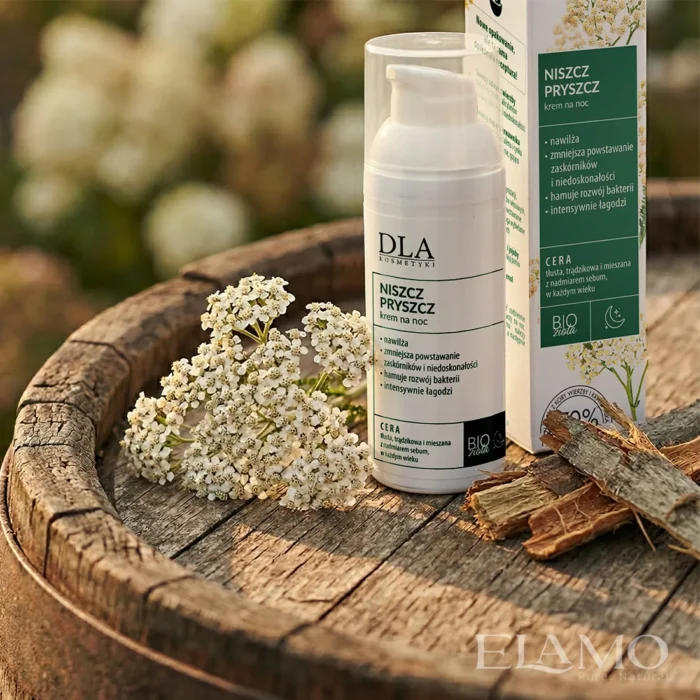 Niszcz Pryszcz krem na noc – butelka i opakowanie na drewnianej beczce, krwawnik i kora wierzby w tle