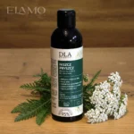 Niszcz Pryszcz płyn – butelka Kosmetyki DLA na drewnie, obok białe kwiatostany krwawnika i zielone gałązki, 95% naparu z ziół