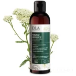 Niszcz Pryszcz płyn do twarzy Kosmetyki DLA – butelka 200 ml, 95% naparu z ziół, w tle białe kwiatostany krwawnika