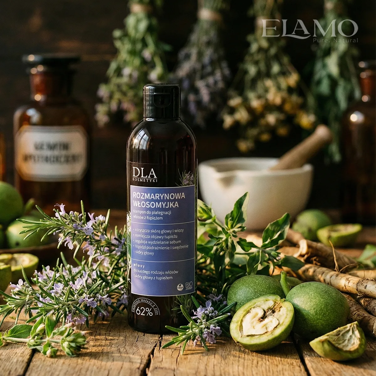 Szampon Rozmarynowa Włosomyjka na stole zielarza w otoczeniu moździerza, słoików aptekarskich i świeżych ziół.