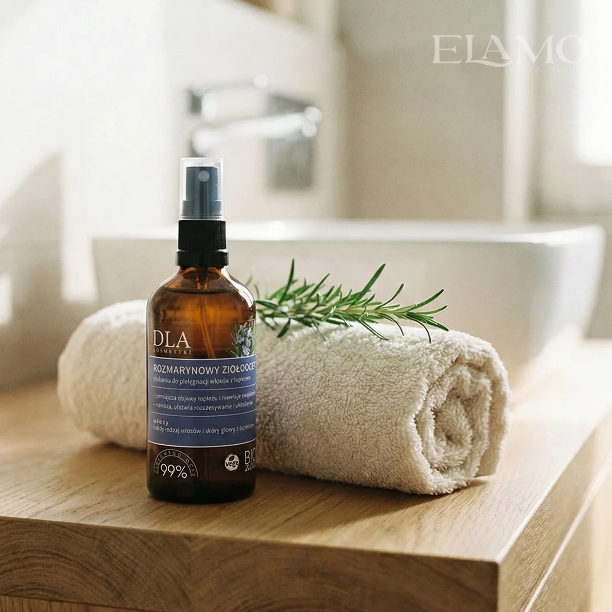 Szklana butelka Rozmarynowego Ziołooctu stojąca na drewnianej półce łazienkowej.