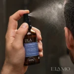 Mężczyzna aplikujący Rozmarynowy Ziołoocet w sprayu bezpośrednio na włosy.