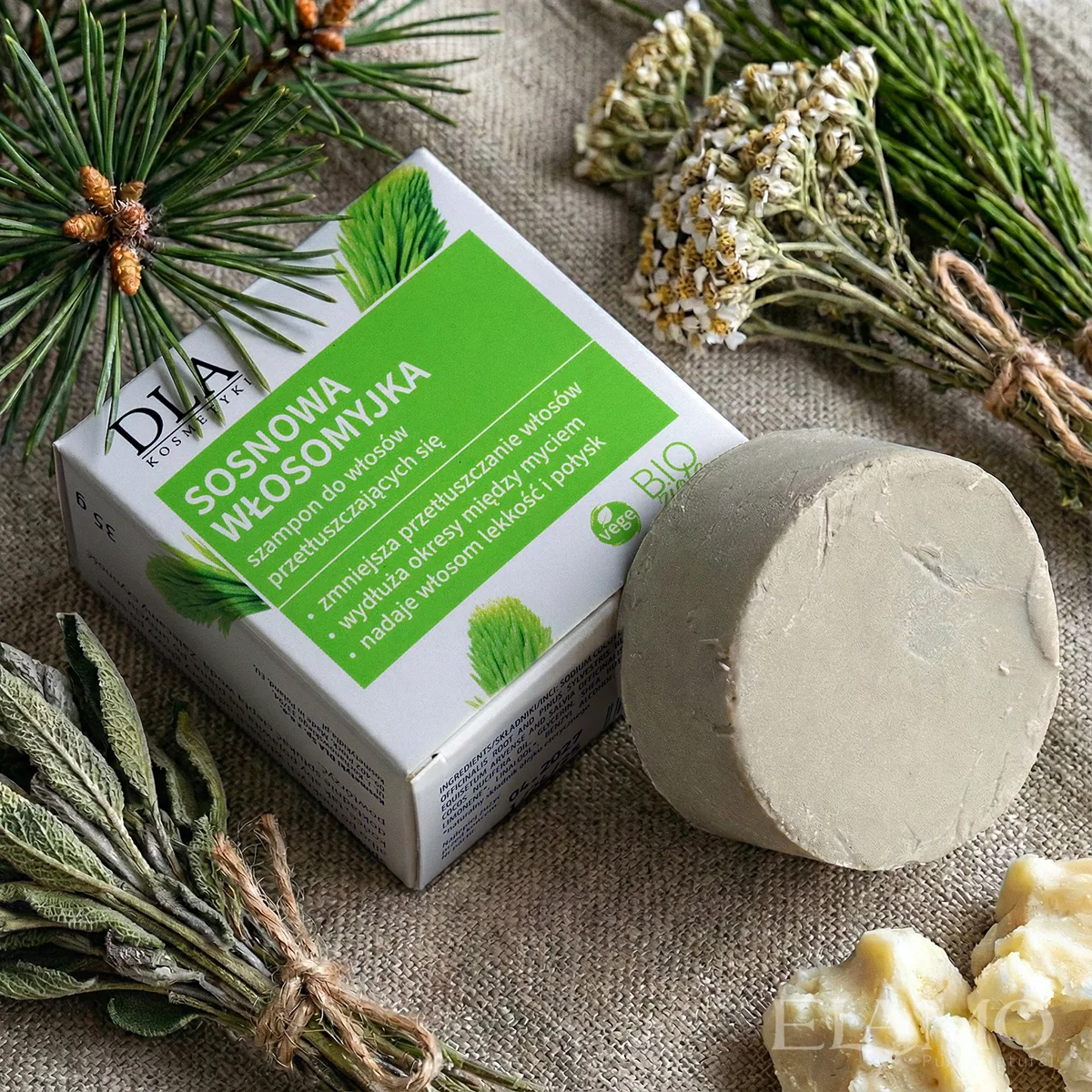 Sosnowa Włosomyjka w otoczeniu gałązek sosny, suszonego krwawnika i szałwii na lnianym tle.