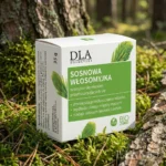 Pudełko szamponu Sosnowa Włosomyjka stojące na mchu w lesie sosnowym.