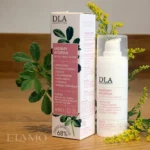 Ukoimy Atopika Krem na drewnianym tle z kwiatami nawłoci i liśćmi kozieradki