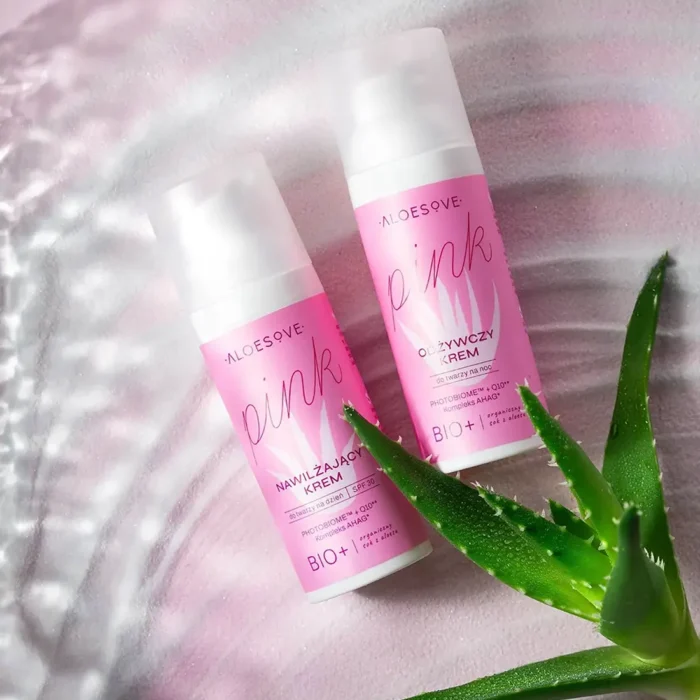 dozowniki z kremem nawilżającym do twarzy ALOESOVE Pink z SPF 30, zaprojektowane w jasnoróżowej tonacji z białymi akcentami. Na opakowaniu widnieje nazwa produktu i informacje o składnikach takich jak fotobiom i koenzym Q10.
