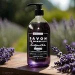 Naturalne mydło marsylskie lawendowe Bômance 1L – butelka mydła w otoczeniu świeżych gałązek lawendy, emanująca relaksującym, kwiatowym aromatem, 98% składników naturalnych, idealne do codziennej pielęgnacji ciała i dłoni