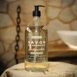 Mydło marsylskie w płynie naturalne 98% oliwa z oliwek, bez oleju palmowego, marki Bômance, 1 litr, ustawione na drewnianym stoliku w łazience