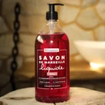 Naturalne różane mydło marsylskie w płynie "Rose" marki Bômance, 1 litr, prezentowane na drewnianym stoliku w przytulnej scenerii łazienkowej