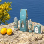 Kolekcja produktów Tadé Réveil en Sicile – dyfuzor zapachowy, uzupełnienie, odświeżacz powietrza i świeczka z cytrusowym aromatem na tle sycylijskiego krajobrazu