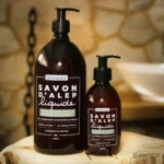 Naturalne mydło Aleppo w płynie Bômance 300 ml oraz 1 litr - ekologiczne mydło na bazie oliwy z oliwek i oleju laurowego, w rustykalnej scenerii łazienkowej, produkt idealny do codziennej pielęgnacji skóry wrażliwej, francuska jakość