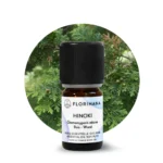 Olejek eteryczny hinoki Florihana – butelka 5 ml na tle gałązek cyprysu japońskiego (Chamaecyparis obtusa).