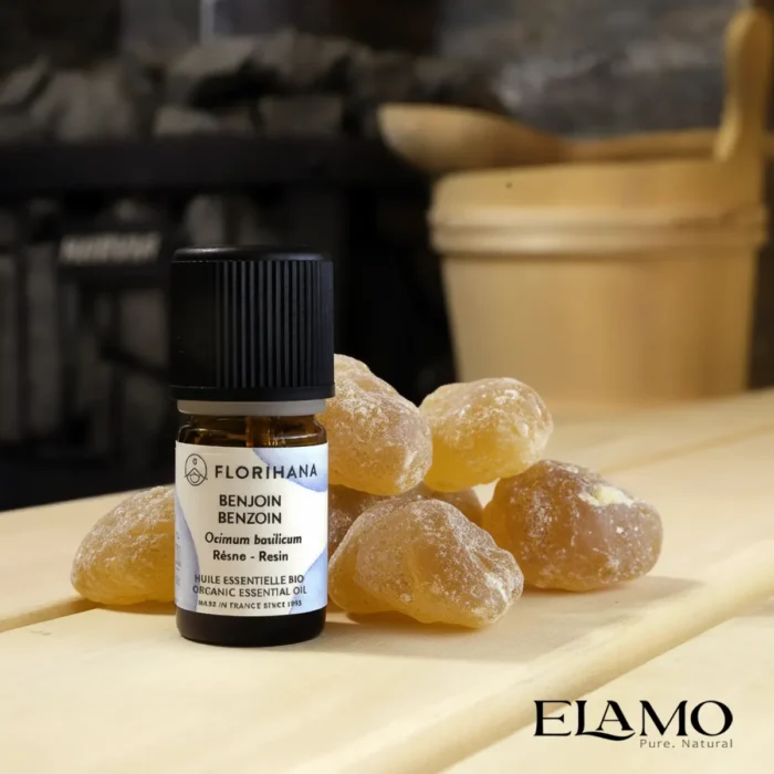 Olejek benzoin (benzoesowy) BIO Florihana — żywica Styrax tonkinensis; flakon na tle naturalnych grudek benzoesu w saunie suchej