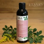 Ukoimy Atopika płyn do kąpieli dla skóry atopowej – zdjęcie produktowe na drewnianym tle, z zielonymi liśćmi i żółtymi kwiatami (Kosmetyki DLA).