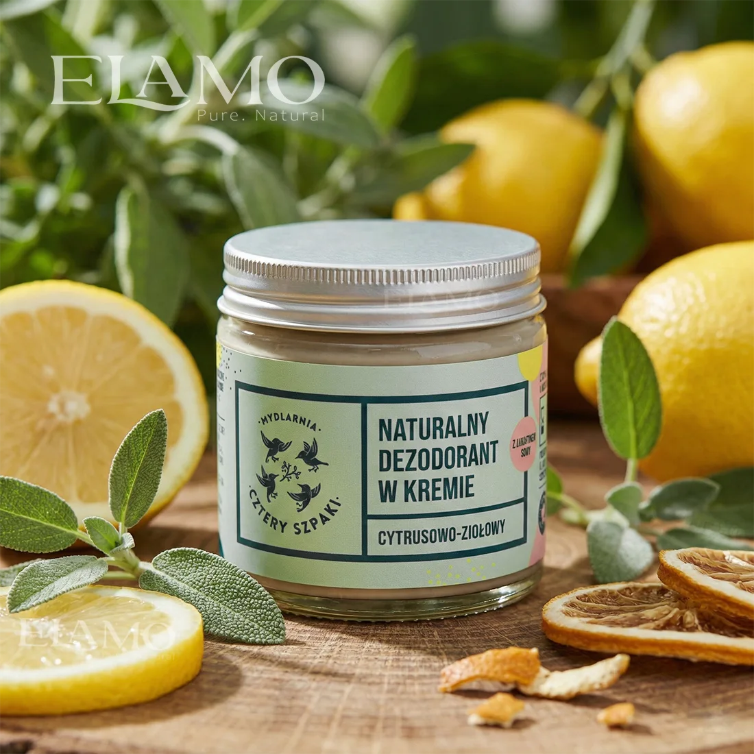 Naturalny dezodorant w kremie cytrusowo-ziołowy w aranżacji z cytrusami i zielonymi liśćmi
